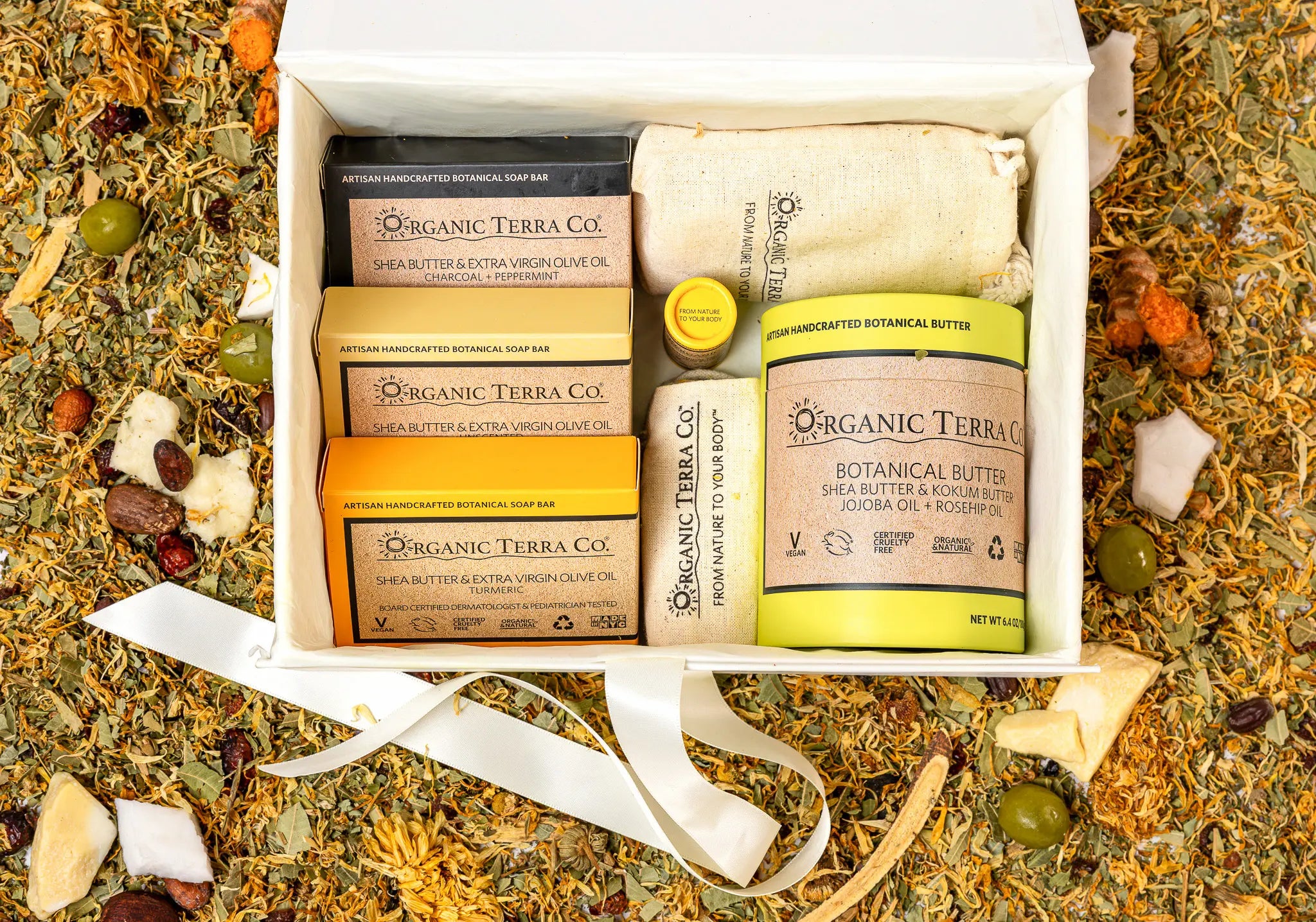 Organic Terra Co. Signature Gift Collection in an open gift box — three botanical soap bars, Botanical Butter, lip balm and soap saver pouch