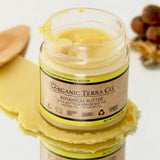 ORGANIC TERRA CO.® Butter with shea butter and kokum butter showing rich creamy texture with wooden spatula and rosehip berries on white background