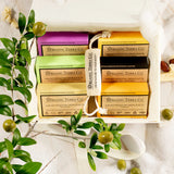 Organic Terra Co. Botanical Cleansing Collection gift box holding six soap bars, styled with fresh olive branches and a drawstring sachet.