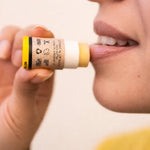 Woman applying ORGANIC TERRA CO.® Botanical Lip Balm with shea butter jojoba oil and rosehip oil in closeup lifestyle shot