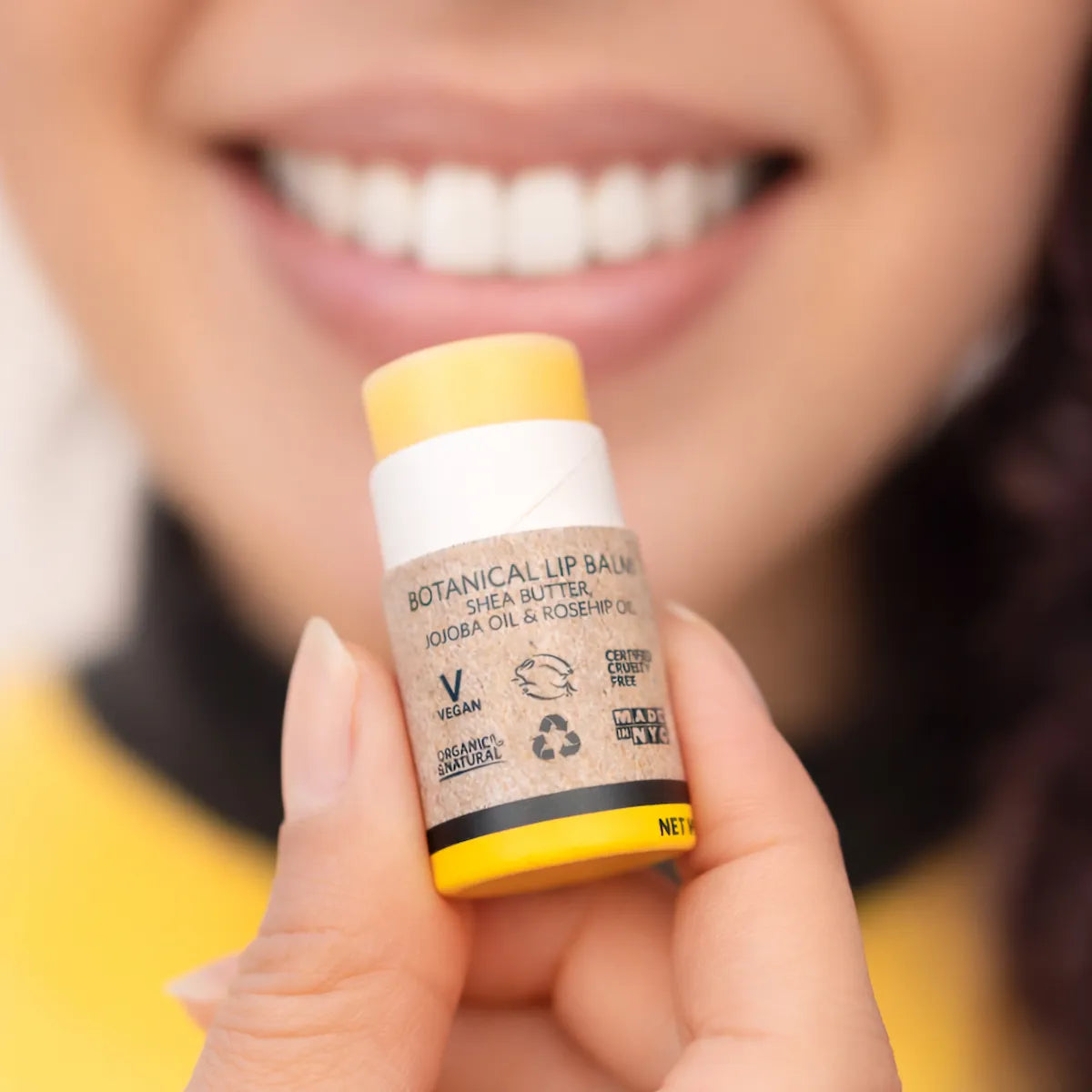 ORGANIC TERRA CO.® Lip Balm with shea butter jojoba oil and rosehip oil held by smiling woman