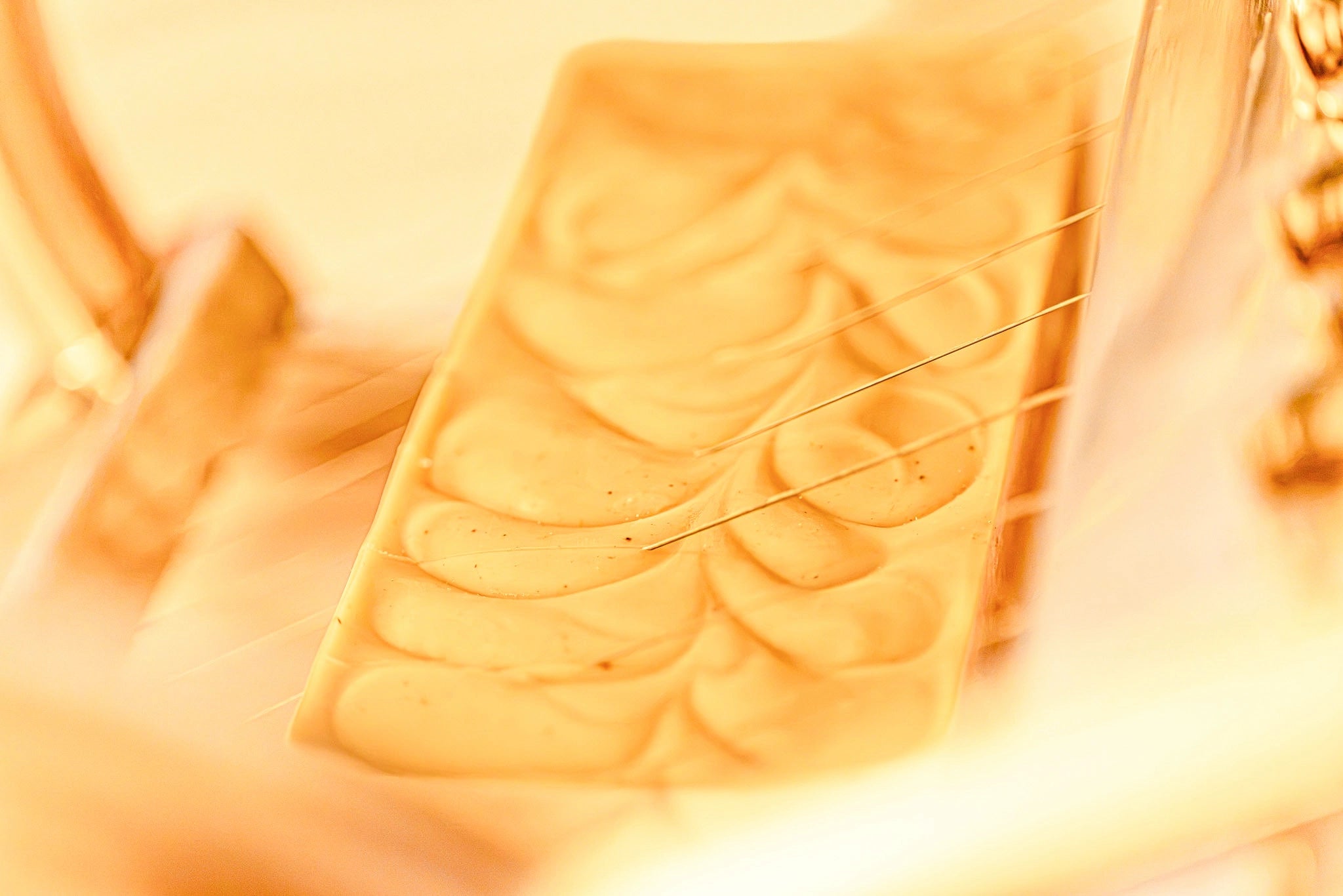 Organic Terra Co. botanical soap bar — close-up of the hand-swirled top texture in warm golden light.