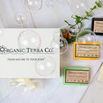 Organic Terra Co. Botanical Cleansing Trio — white gift box with ribbon and three handcrafted botanical soap bars on a soft towel