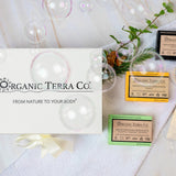 Organic Terra Co. Botanical Cleansing Trio — white gift box with ribbon and three handcrafted botanical soap bars on a soft towel