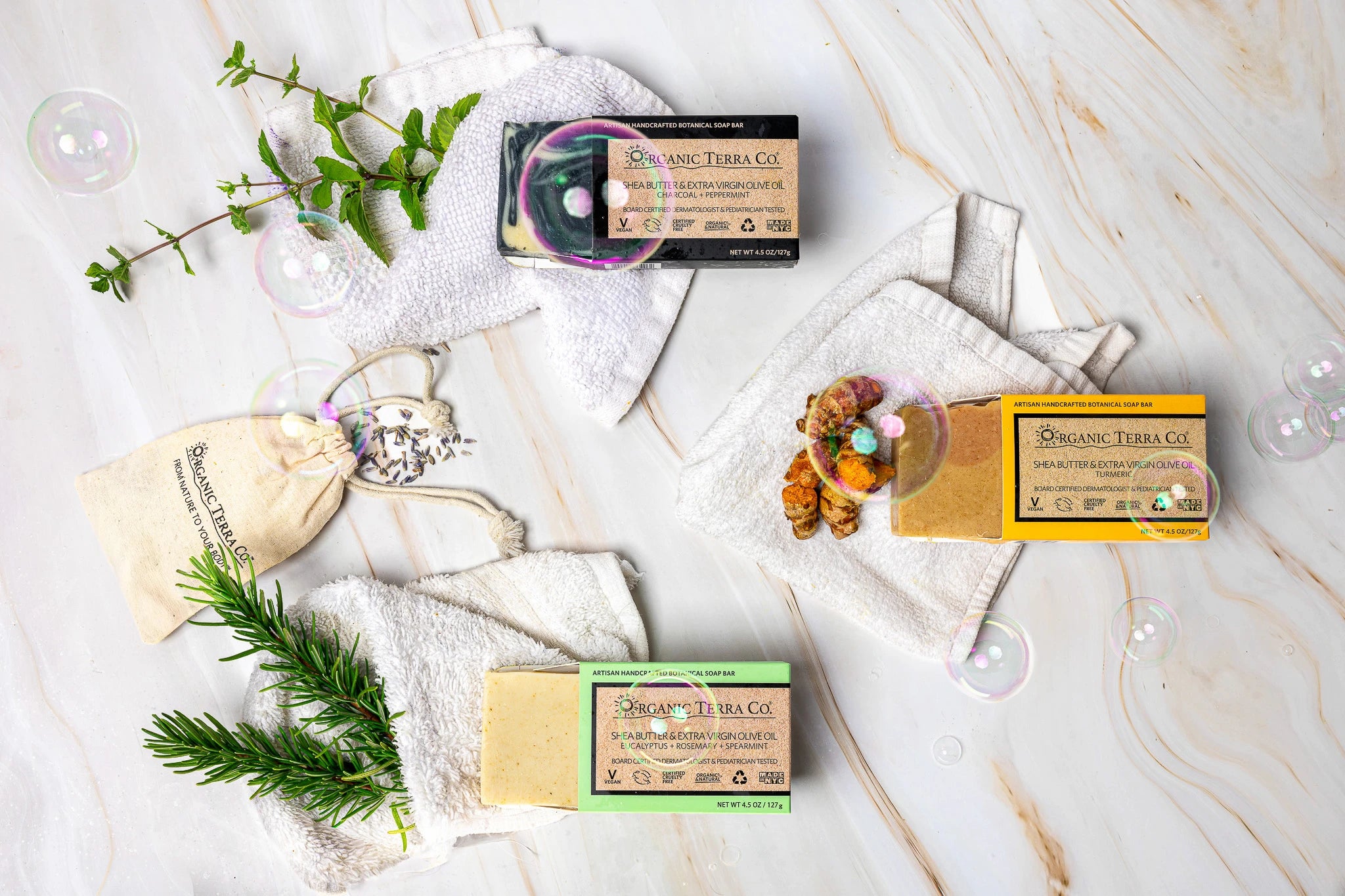 Organic Terra Co. Botanical Cleansing Trio — three handcrafted botanical soap bars shown as a sample of available scents, with fresh botanicals