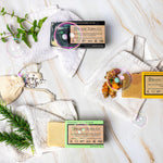 Organic Terra Co. Botanical Cleansing Trio — three handcrafted botanical soap bars shown as a sample of available scents, with fresh botanicals