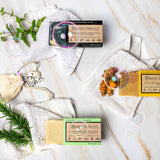 Organic Terra Co. Botanical Cleansing Trio — three handcrafted botanical soap bars shown as a sample of available scents, with fresh botanicals