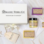 Organic Terra Co. Daily Collection — white gift box with ribbon, two botanical soap bars, 6.4 oz Botanical Butter, lip balm and dried-lavender sachet on a soft towel