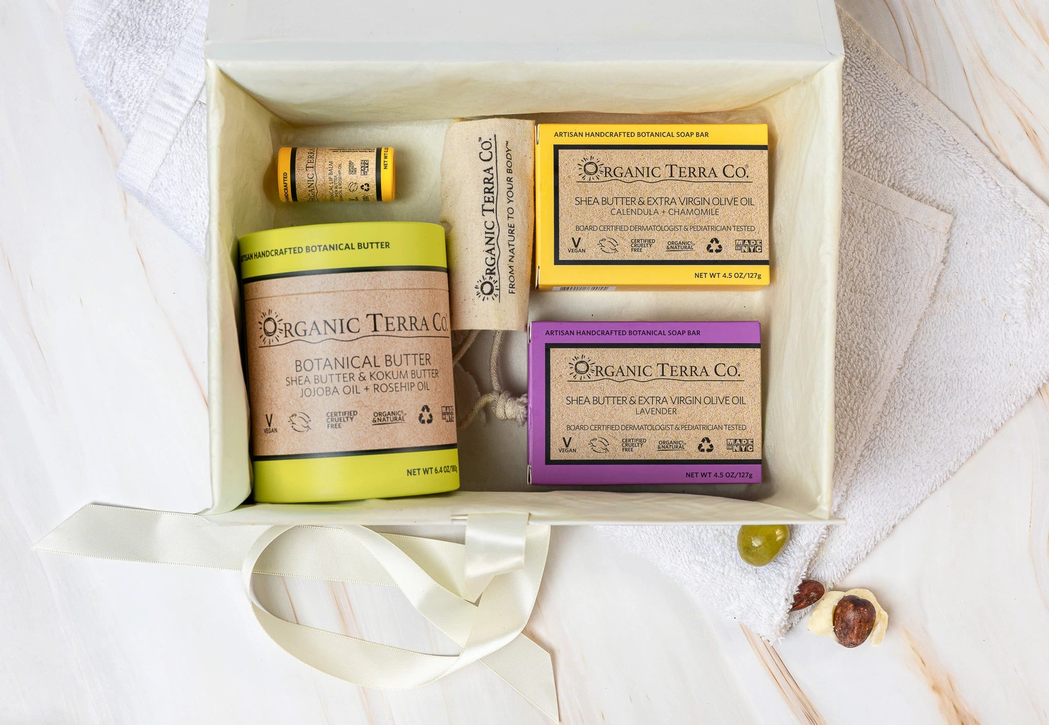 Organic Terra Co. Daily Collection in an open gift box — two botanical soap bars, 6.4 oz Botanical Butter, lip balm and lavender sachet