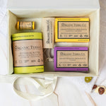 Organic Terra Co. Daily Collection in an open gift box — two botanical soap bars, 6.4 oz Botanical Butter, lip balm and lavender sachet