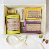 Organic Terra Co. Daily Collection in an open gift box — two botanical soap bars, 6.4 oz Botanical Butter, lip balm and lavender sachet