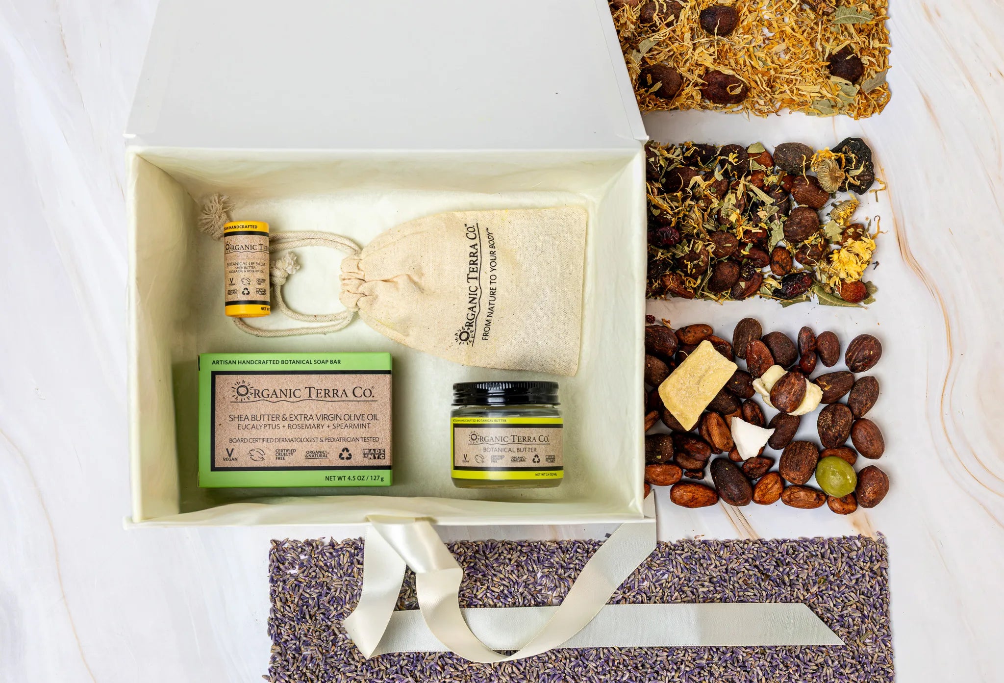 Organic Terra Co. Discovery Collection in an open gift box — botanical soap bar, 2.4 oz Botanical Butter, lip balm and lavender sachet