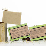 ORGANIC TERRA CO.®Shea Butter Extra
Virgin Olive Oil Eucalyptus Rosemary and
Spearmint soap bar front and back packaging with unwrapped bar and scattered shea nuts olives and cacao beans