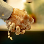 Hands lathering ORGANIC TERRA CO.®botanical soap bar producing rich creamy foam with water dripping