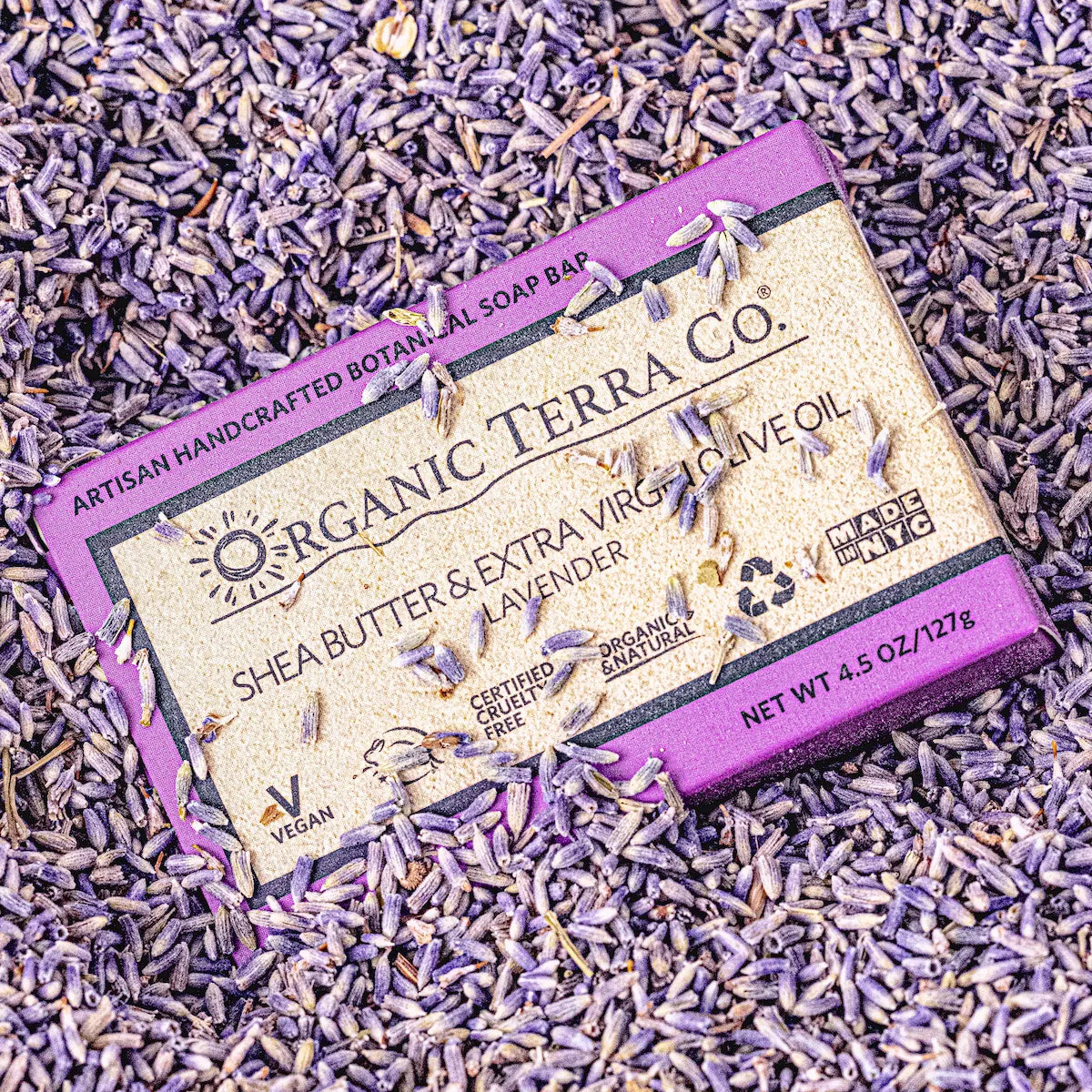 ORGANIC TERRA CO.®Shea Butter Extra Virgin Olive Oil Lavender soap bar box surrounded by and covered in dried lavender buds in overhead flatlay