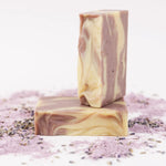 ORGANIC TERRA CO.®handcrafted Shea Butter Extra Virgin Olive Oil Lavender soap bars stacked surrounded by lavender powder and dried lavender buds on white background