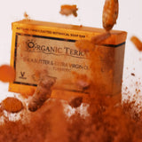 ORGANIC TERRA CO.®Shea Butter Extra Virgin Olive Oil Turmeric soap bar box emerging dramatically from turmeric powder cloud with fresh turmeric root pieces