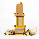 ORGANIC TERRA CO.® Extra Virgin Olive Oil Turmeric soap bar front and back packaging stacked with unwrapped bars and scattered turmeric root olives shea nuts and coconut